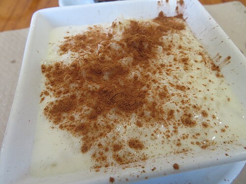 A bowl of arroz con leche dusted with ground cinnamon